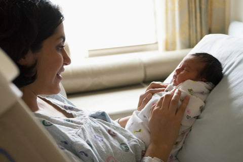 New mother looking at her newborn baby