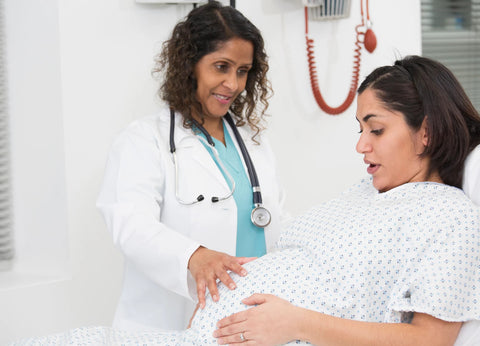 OB Gynecologist checking tummy of pregnant woman