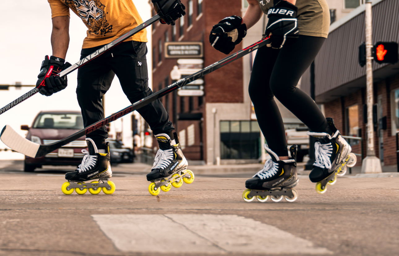 close up of two people's feet as they roller skate down the street