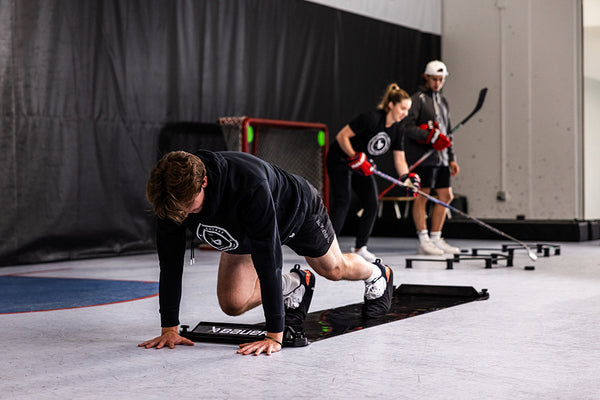 Hockey player in lunge position on slide board training tool