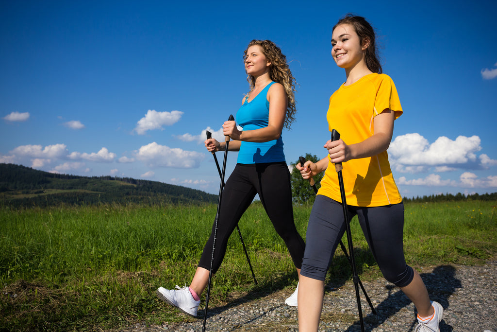 Zwei Frauen trainieren Nordic Walking im Freien