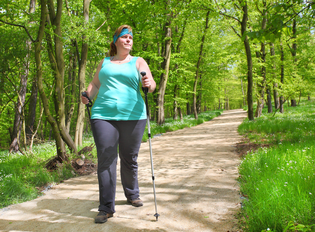 Frau geniesst Nordic Walking im Park