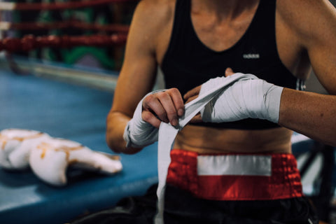 Boxerin bindet sich Boxbandage um das Handgelenk