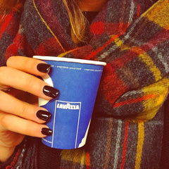 Woman Holding a Lavazza Paper cup. Its a small paper cup