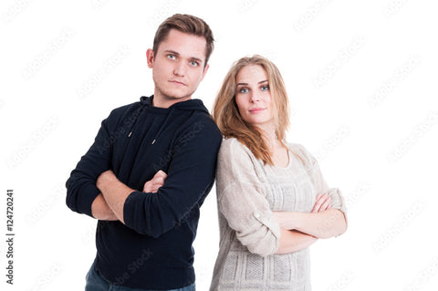 Couple posing and standing with arms crossed back to back