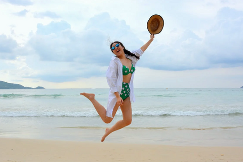 Woman Jumping on Seashore and Hold Woman Jumping on Seashore and Holding Hating Hat