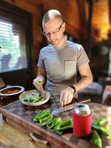 Greg making food on a large cutting board