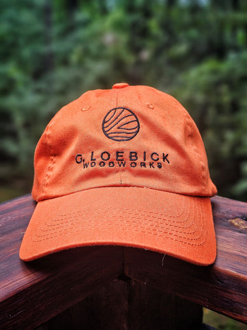 An orange hat featuring the logo of G. Loebick Woodworks, maker of custom wood maps