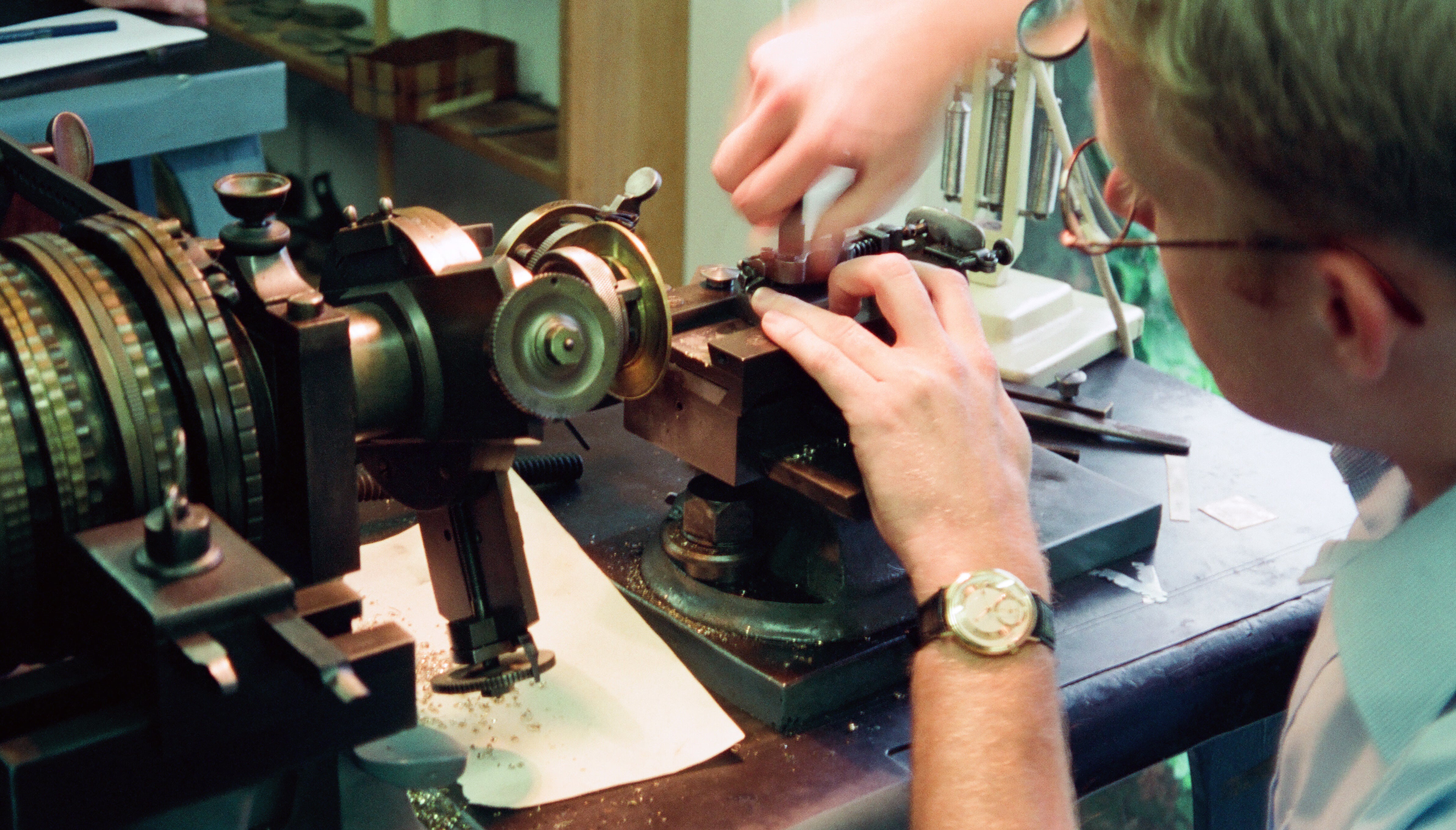 Roger W. Smith watchmaker at a lathe in the workshop on the isle of man for A Collected Man London