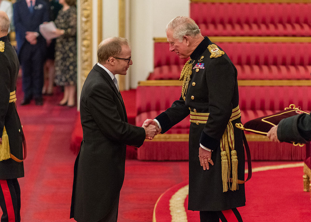 Roger W. Smith watchmaker receiving his OBE from Prince Charles for A Collected Man London