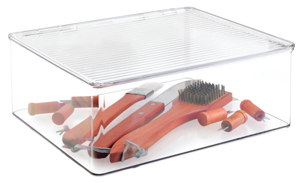 Large clear plastic box on white background containing grill tools and accessories