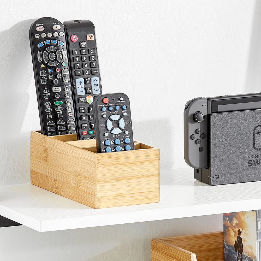 Small Divided Bamboo Storage Bin Holding Remote Controls on White Shelf Next to Nintendo Switch