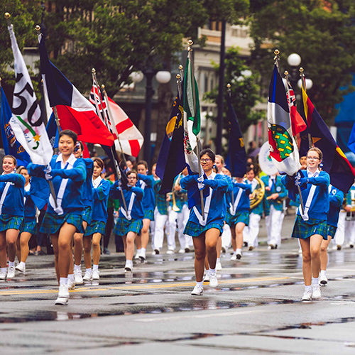 Parade of Cheerleader Girls in Blue Uniforms Holding Flags from Different Countries