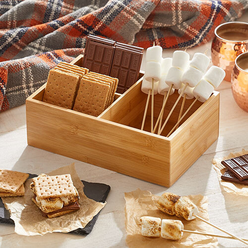 Bamboo Wood Storage Bin Next to Picnic Blanket with Chocolate, Marshmallows and S'more Supplies