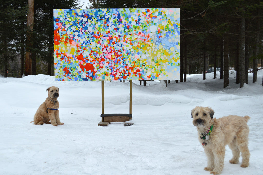 Dogs Lily and Rosie, beside an easel with a large painting by abstract painter Claire Desjardins. It's winter, and there is snow.