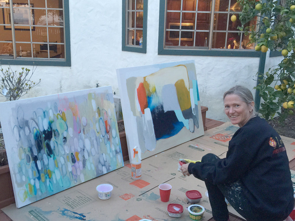 Abstract painter Claire Desjardins painting al fresco in courtyard with lemon tree.