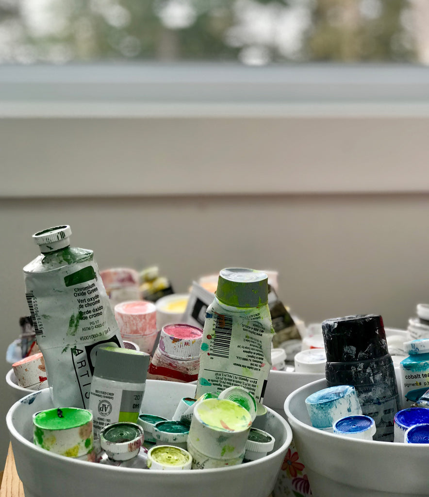 Tubes of acrylic artist paints in pots.