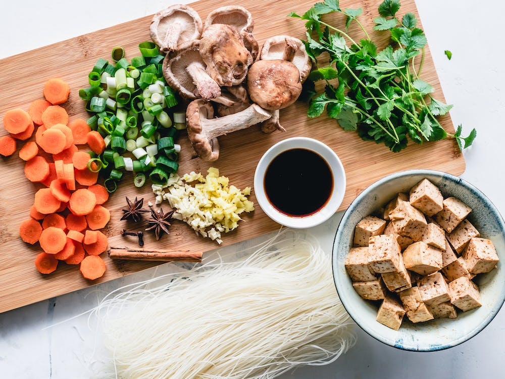 A top view of a vibrant assortment of fresh vegetables and tofu on a table.