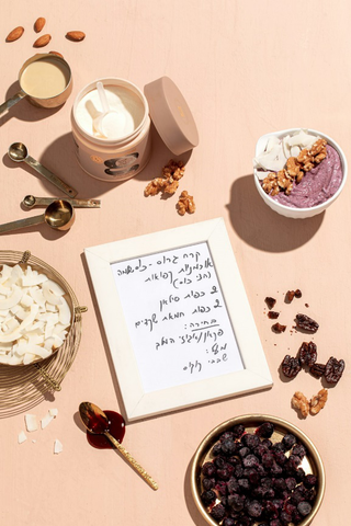 A variety of ingredients and a written recipe on a table indicating the use of collagen powder in a recipe.