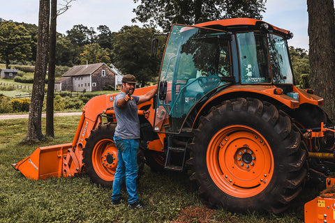 JC standing by a tractor at the Trillium farm