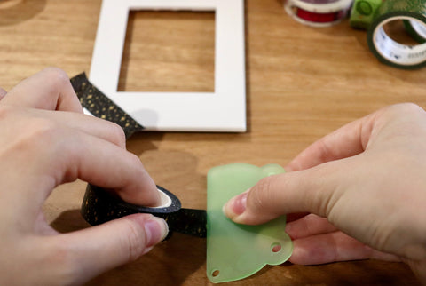 Tearing washi tape using a transparent green blunt edge acrylic shaped frog head.