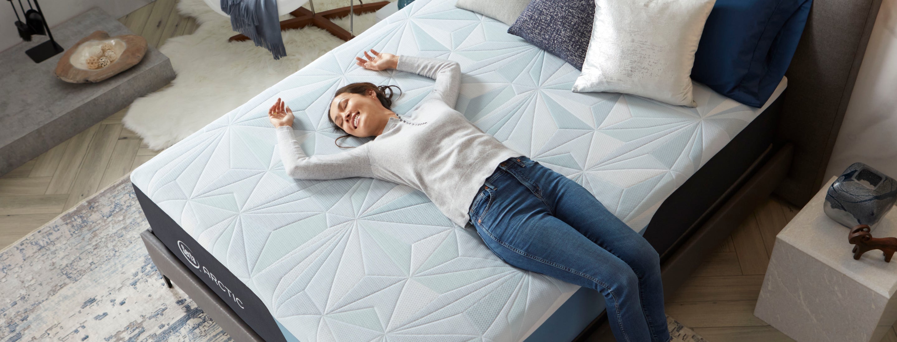 Woman laying happily on her Serta Arctic Mattress smiling
