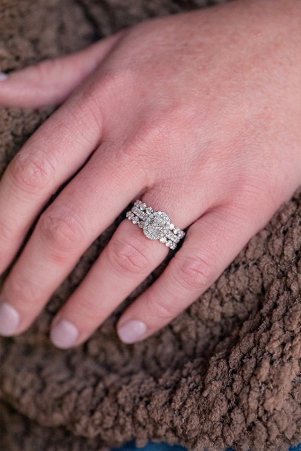 Jessica wearing Henri Daussi Single Shared Prong Diamond Wedding Band in White Gold and Ready-To-Go Oval Diamond Engagement Ring with Halo in White Gold