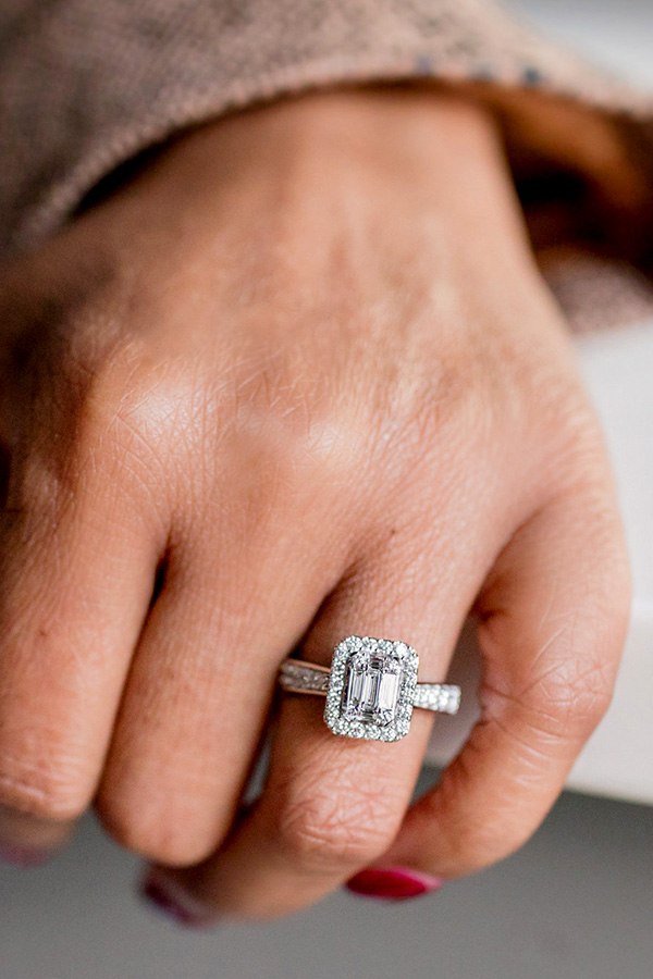 Close up photo of Monica's hand wearing Emerald Cut Halo Diamond Cluster Ring in White Gold