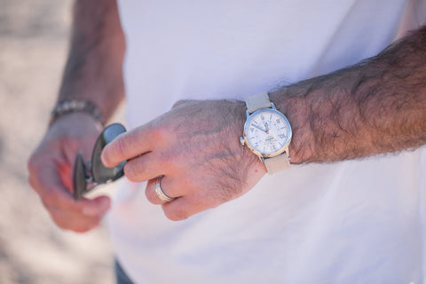 man with a white Shinola watch and white gold wedding ring