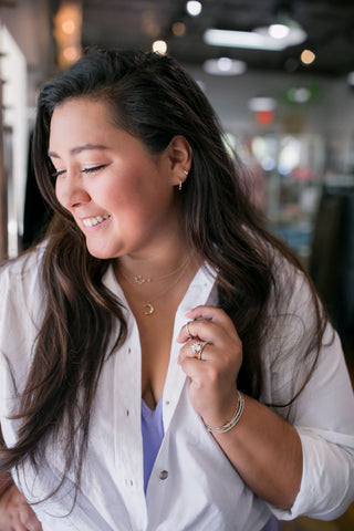 woman with diamond earrings and necklace and a custom wedding ring set by Bremer Jewelry