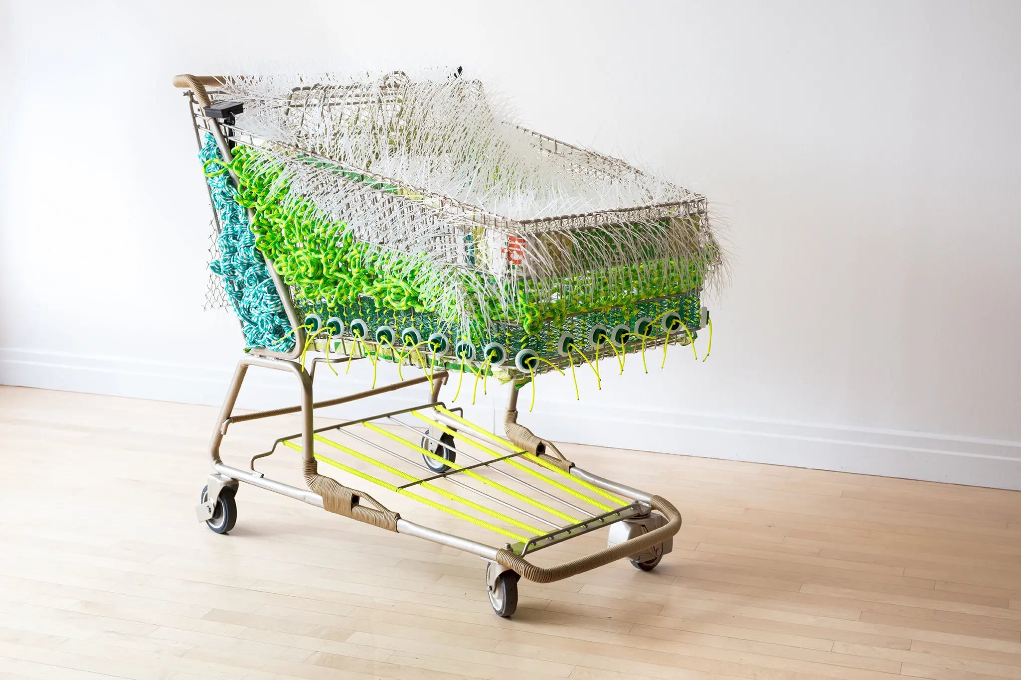 The artist Theda Sandiford used FreshDirect bags to create “Wide Load,” a piece in her Emotional Baggage Carts series.Credit...Sky Garden Gallery