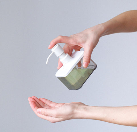 Squeezing sanitiser on hands  