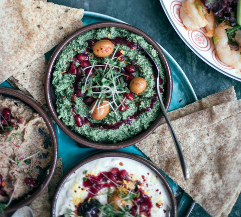 Hummus along with pita and salad and a green dip