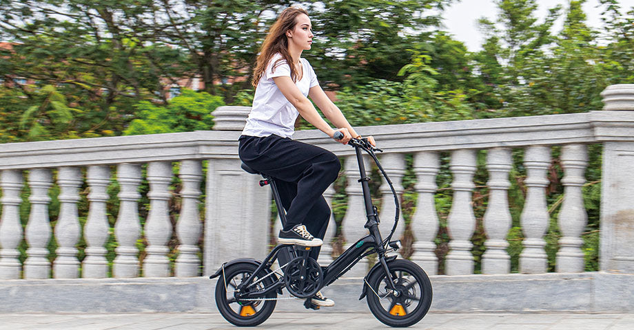Donna che guida la bici elettrica M1pro sul ponte