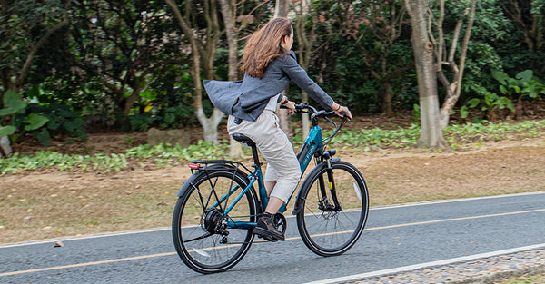 Donna che guida bici elettrica su strada