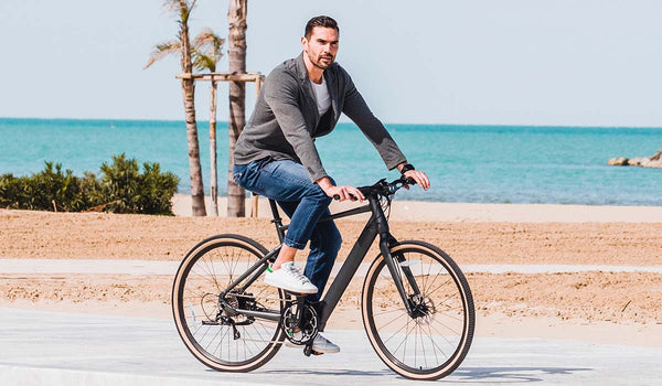 Homme faisant du vélo électrique au bord du lacgo