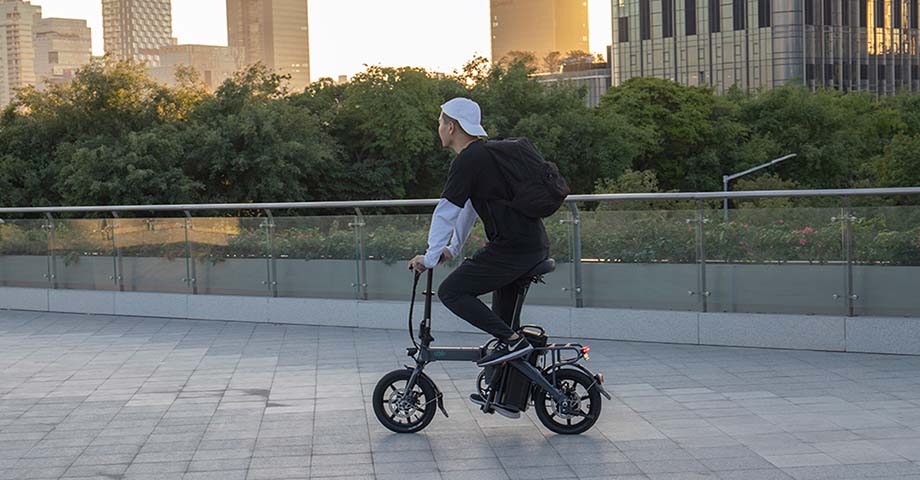 Uomo che guida la bici elettrica Fiido L3 su strada