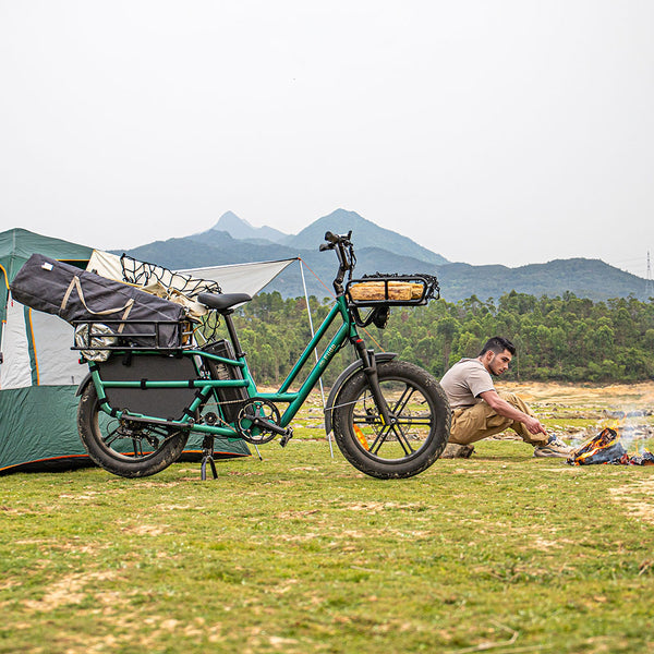 Uomo in campeggio con una bici elettrica accanto
