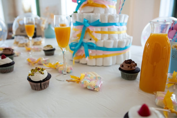 A baby shower table display with a diaper cake and other baby shower trends