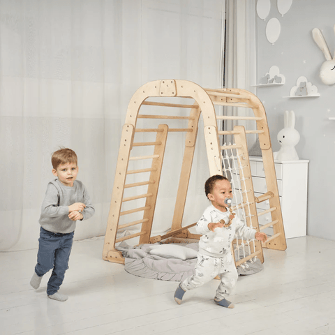 Two toddler boys running around a Goodevas indoor wooden playground for children