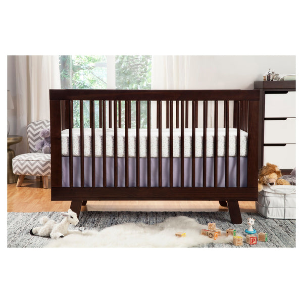 Pottery Barn Kids Babyletto Hudson 3-in-1 convertible best crib 2024 in a nursery with toys laid out in front of it
