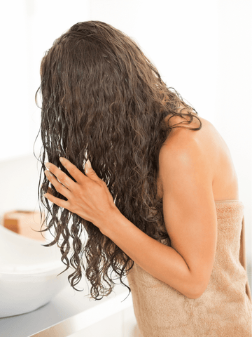 Woman washing her hair the day after oiling