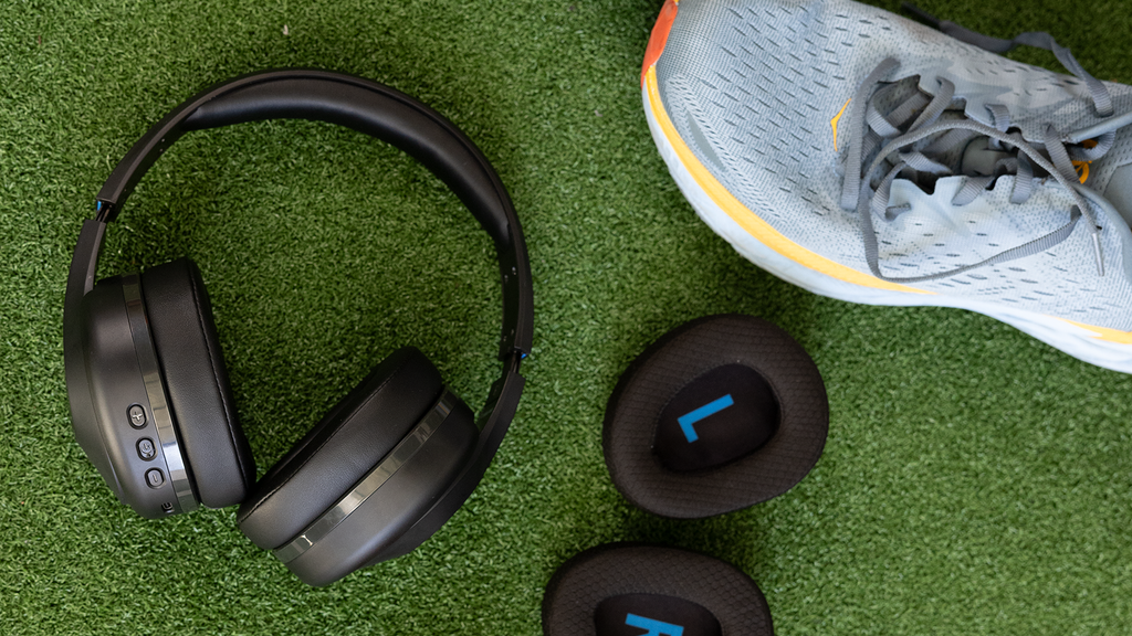 TW340 wireless headphones with replaceable cushions on gym floor next to workout shoes