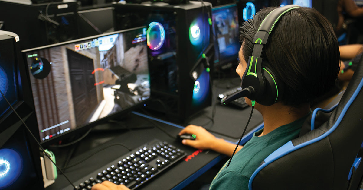 An esports student wearing the ergonomic Victory 250XG Gaming headset, utilizing its mic-enabled feature for clear communication with team members.