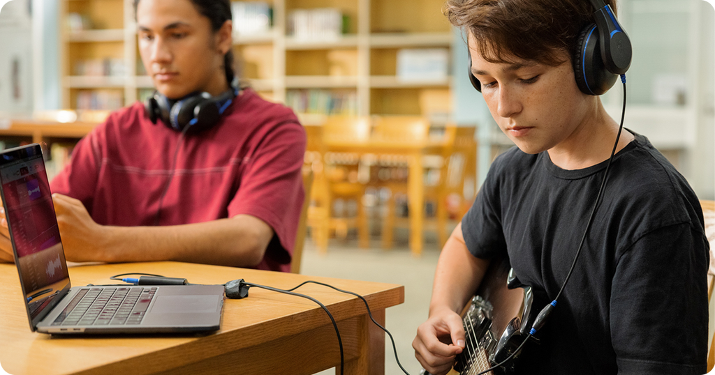 Students using headphones to produce digital music