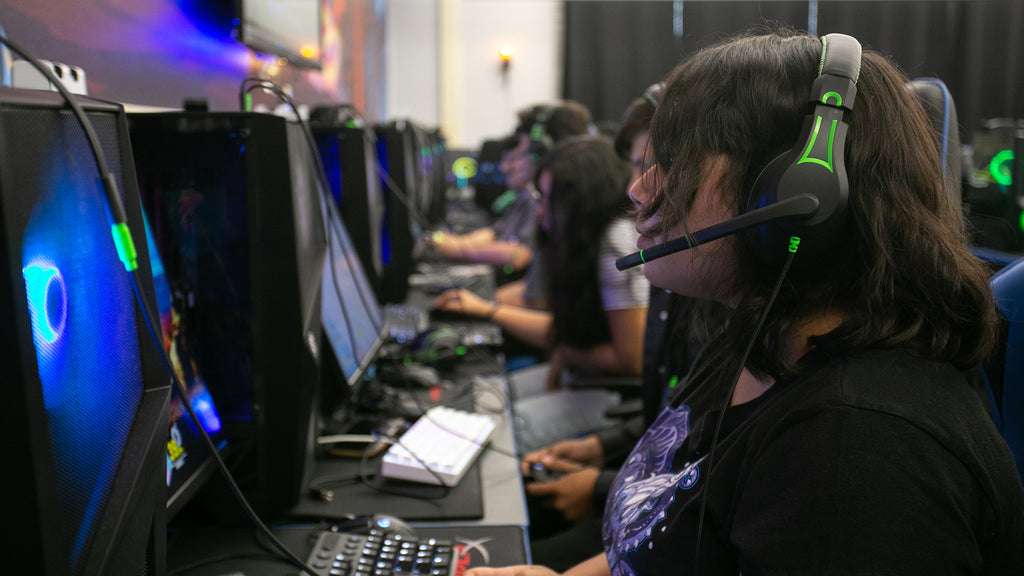 Student participating in an esports school event, using the 250XG Victory Gaming Headset by TWT Audio. The student is using the headset's integrated microphone, engaged in gaming.