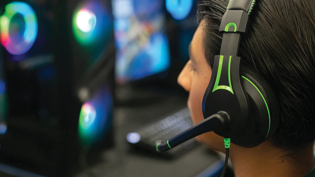 Student using the 250XG Victory Gaming Headset by TWT Audio, speaking into the microphone in front of a PC gaming system.