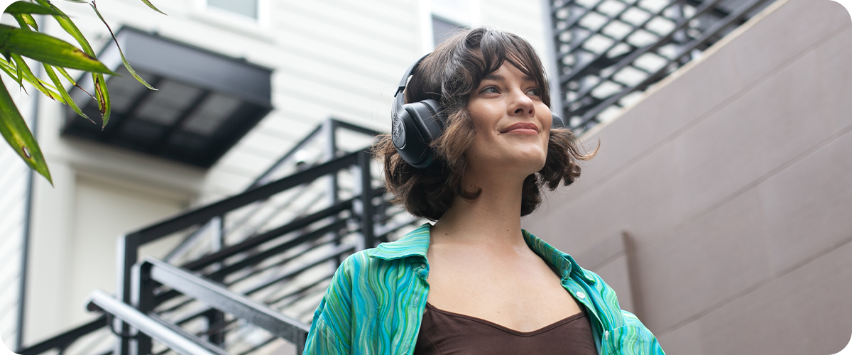 A female walking using wireless headphones, emphasizing the advantages of cord-free use, mobility, and ease of access