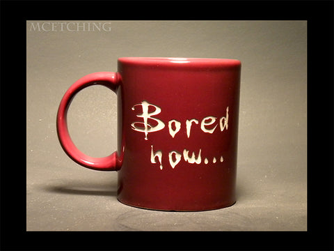 The words Bored Now etched into a ceramic red mug