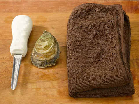 Oyster on Wooden Surface with Towel and Oyster Knife